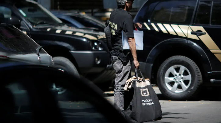 Imagem de um agente da PF carregando uma bolsa com evidências